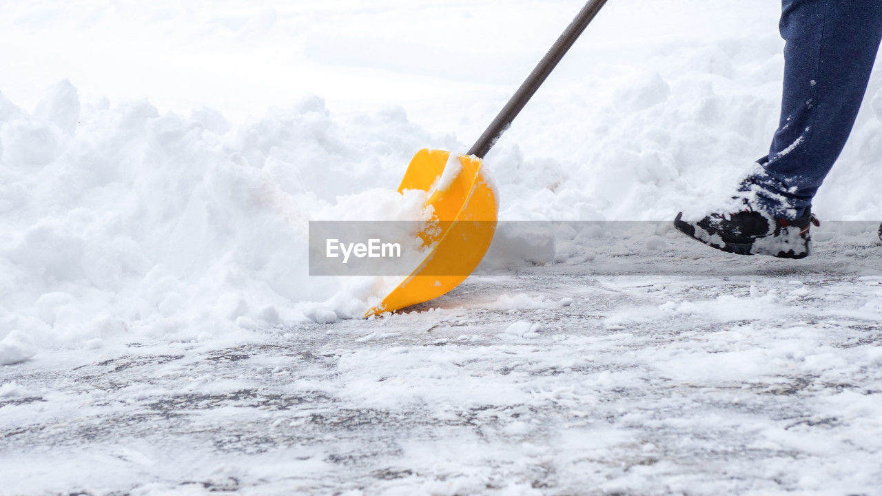 Man shoveling snow off of driveway in heavy snow storm 