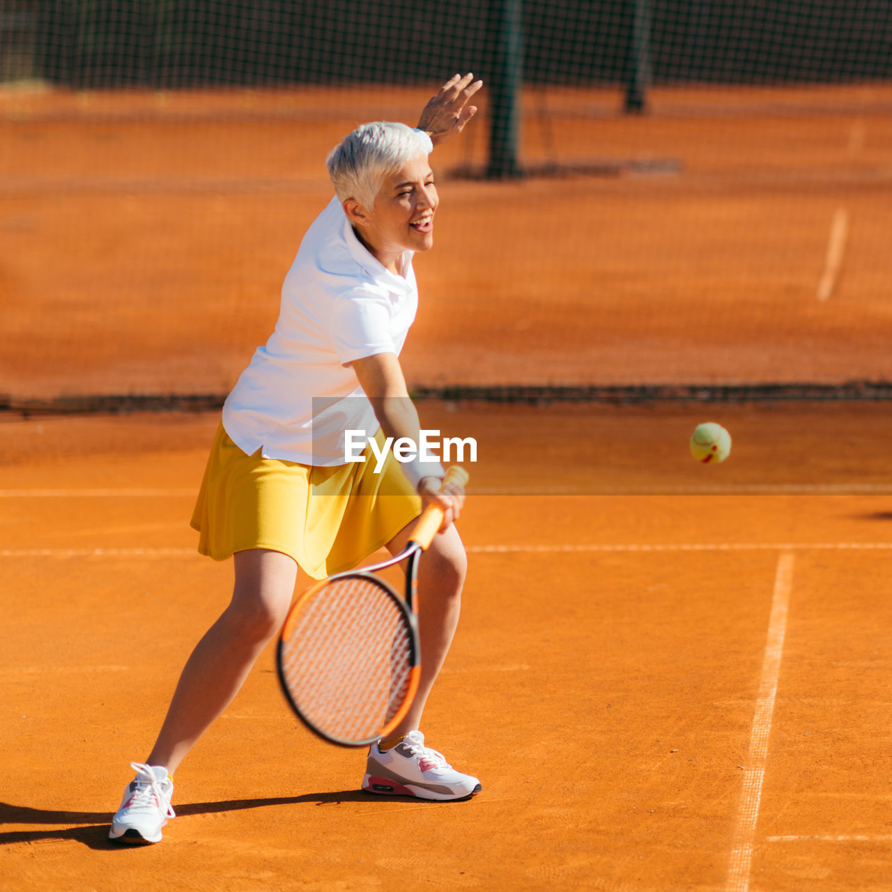 Beautiful mature woman at the tennis court