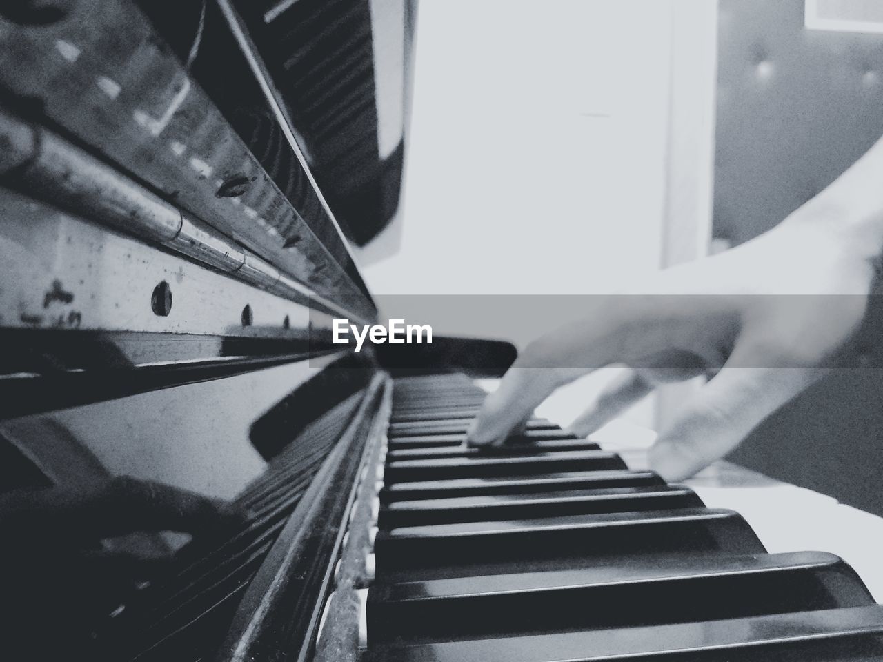 Close-up of human hand playing piano at home