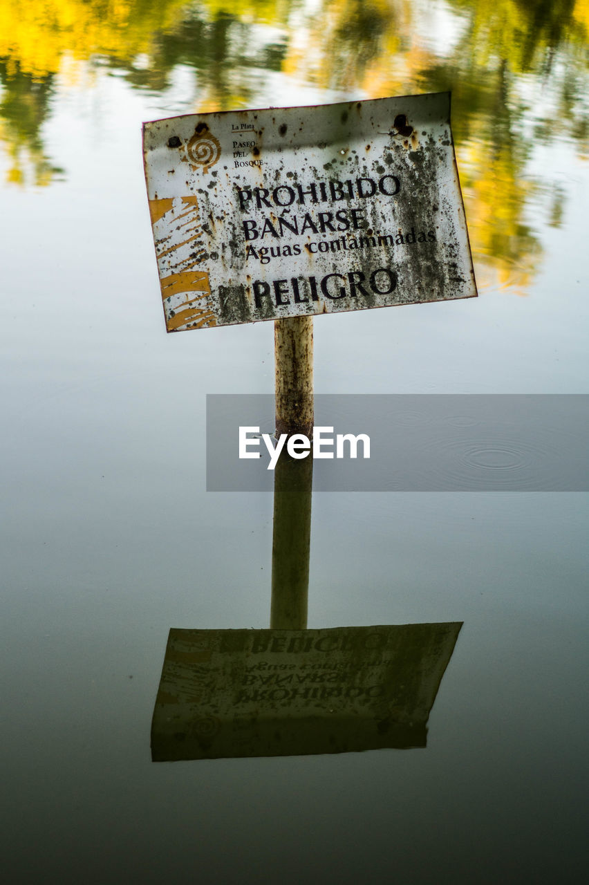 Forbidden sign reflecting in lake