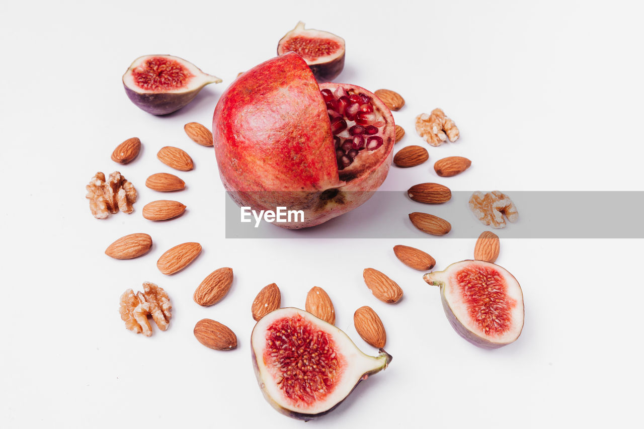 Close-up of pomegranate amidst almonds on table