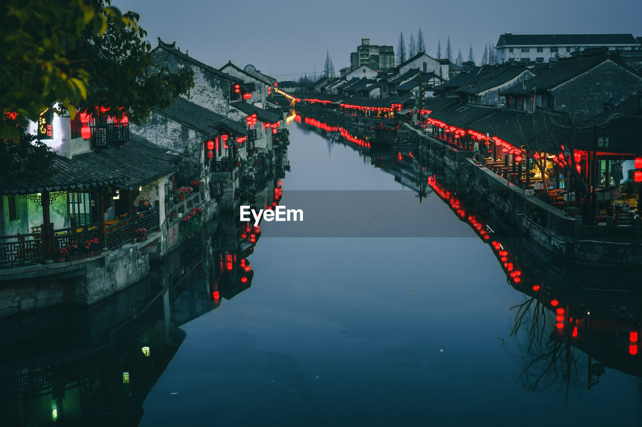 River amidst illuminated houses in town