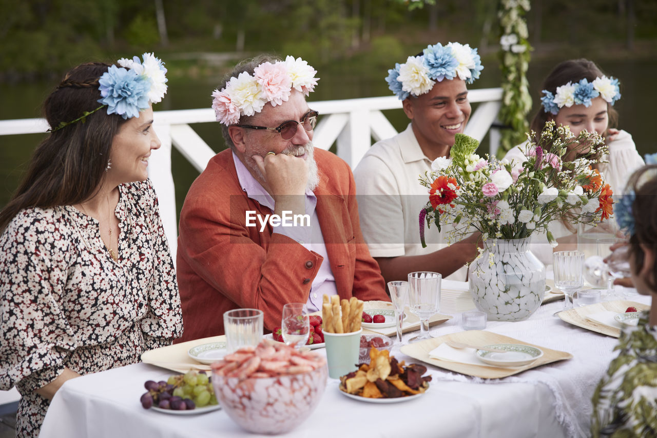 Family having midsummer dinner by lake