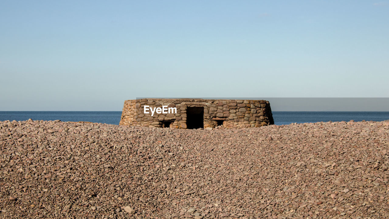 BUILT STRUCTURE ON BEACH AGAINST CLEAR SKY