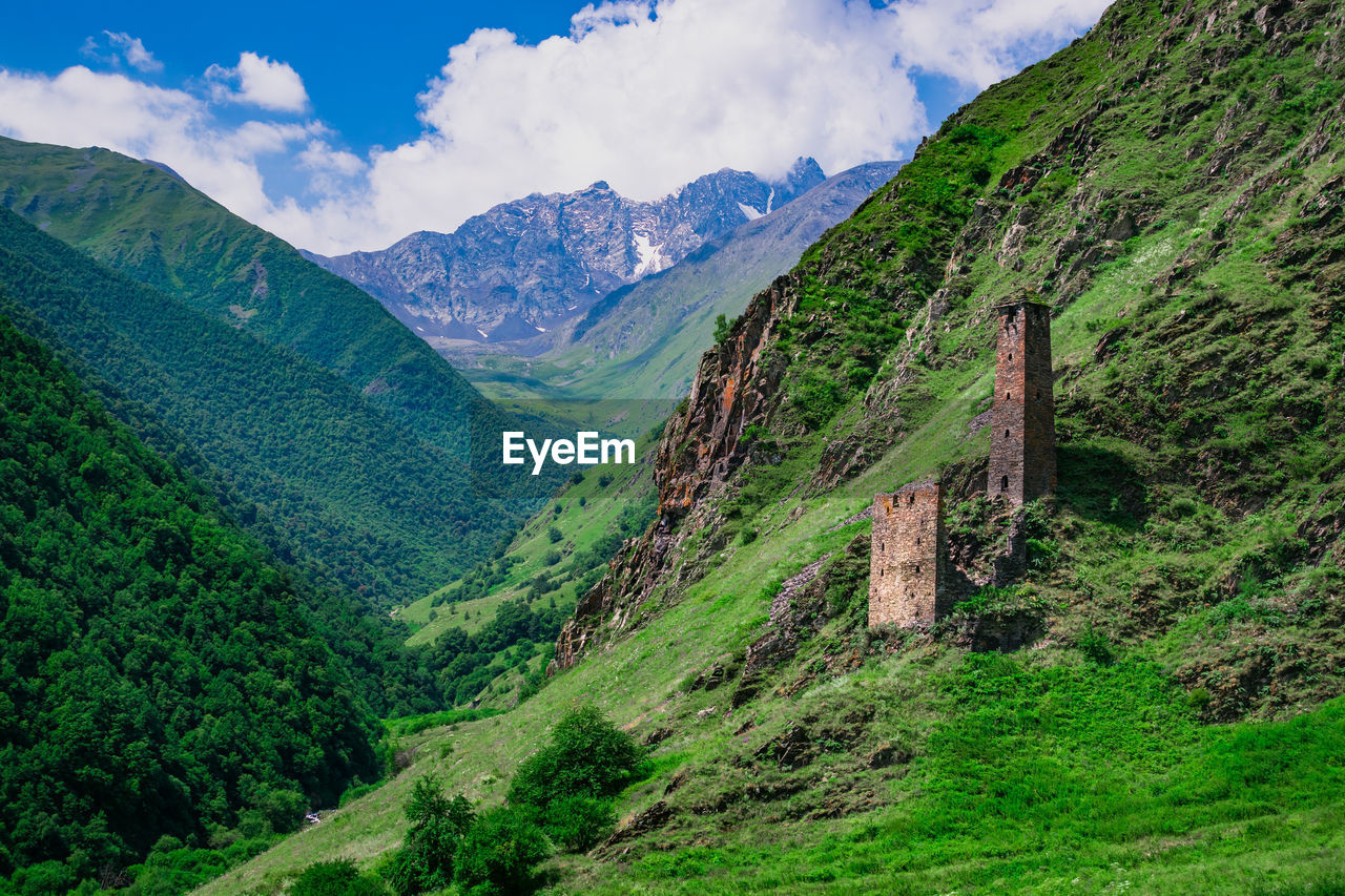 Ancient historical tower in the mountains of chechnya. scenic view of mountains against sky
