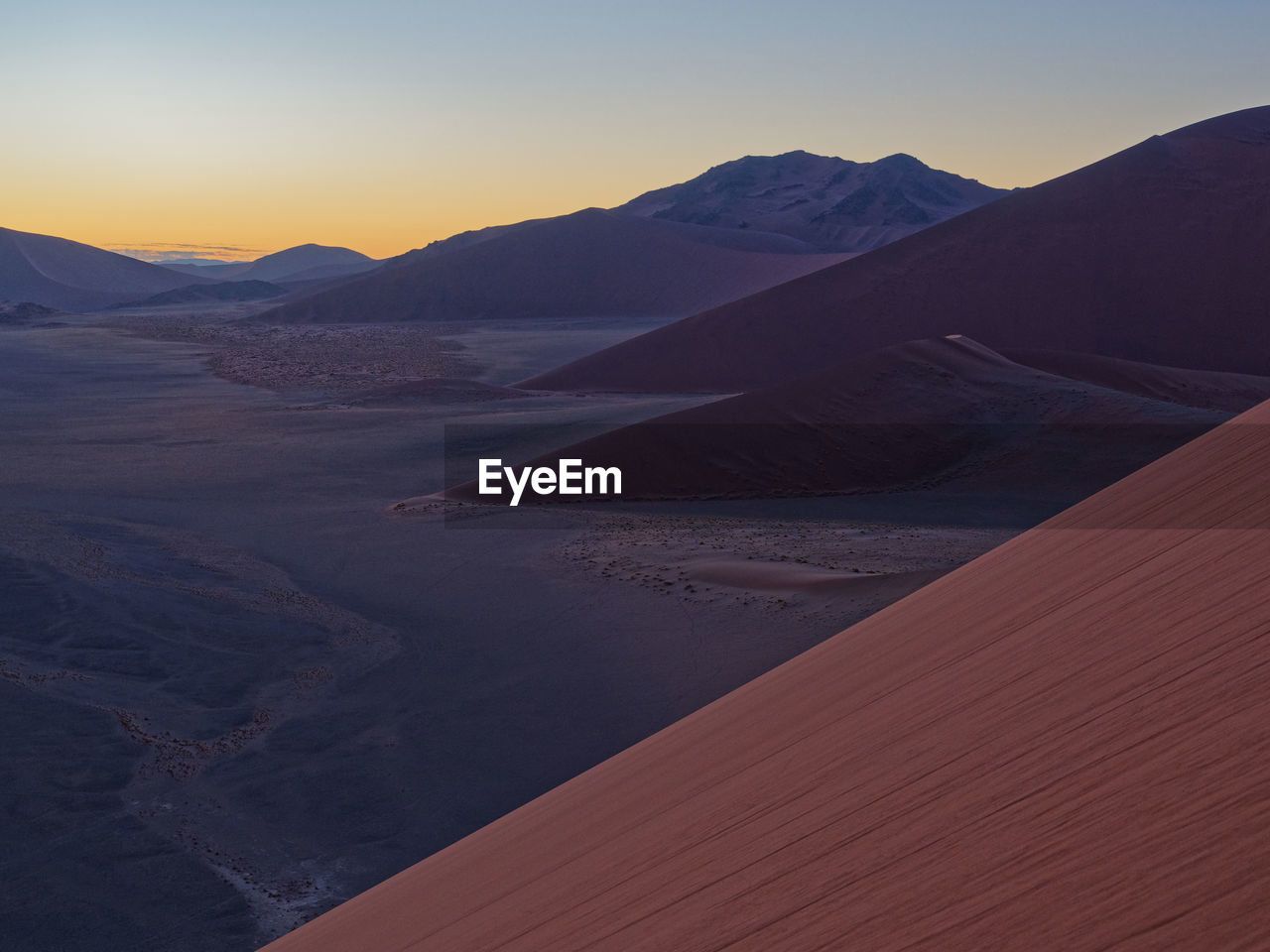 Scenic view of desert against sky during sunset