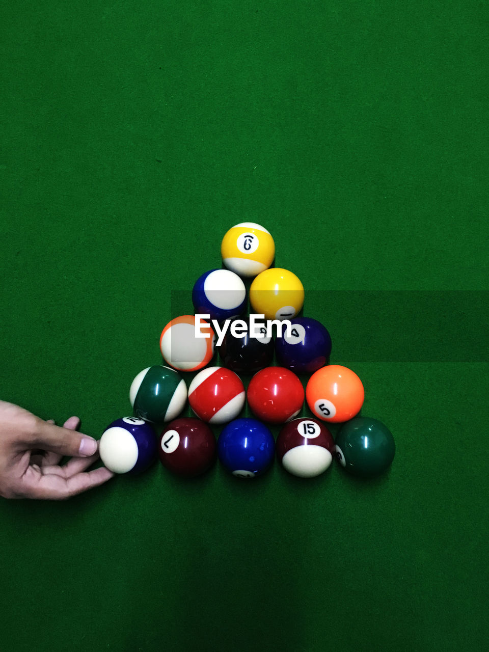 Cropped hand of person with cue ball on table