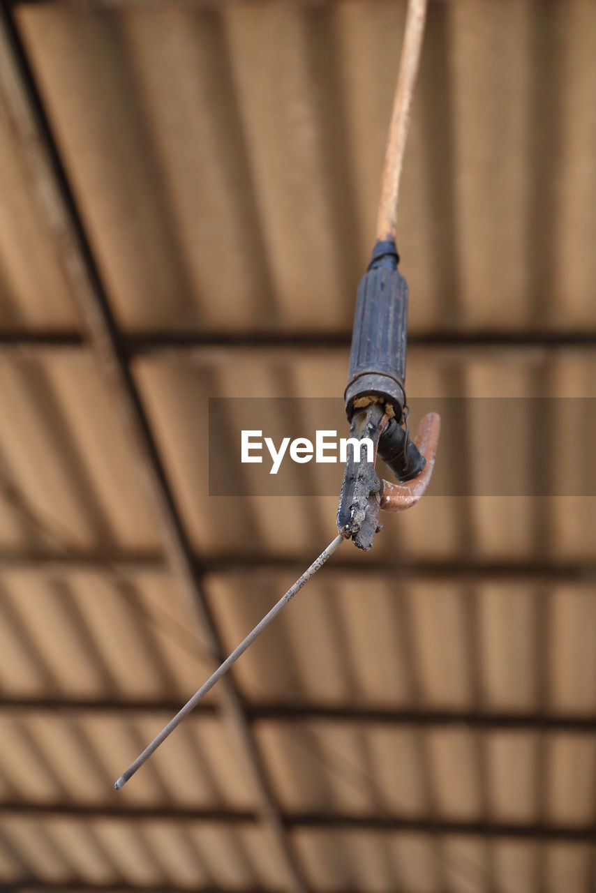 LOW ANGLE VIEW OF ROPES HANGING ON METAL