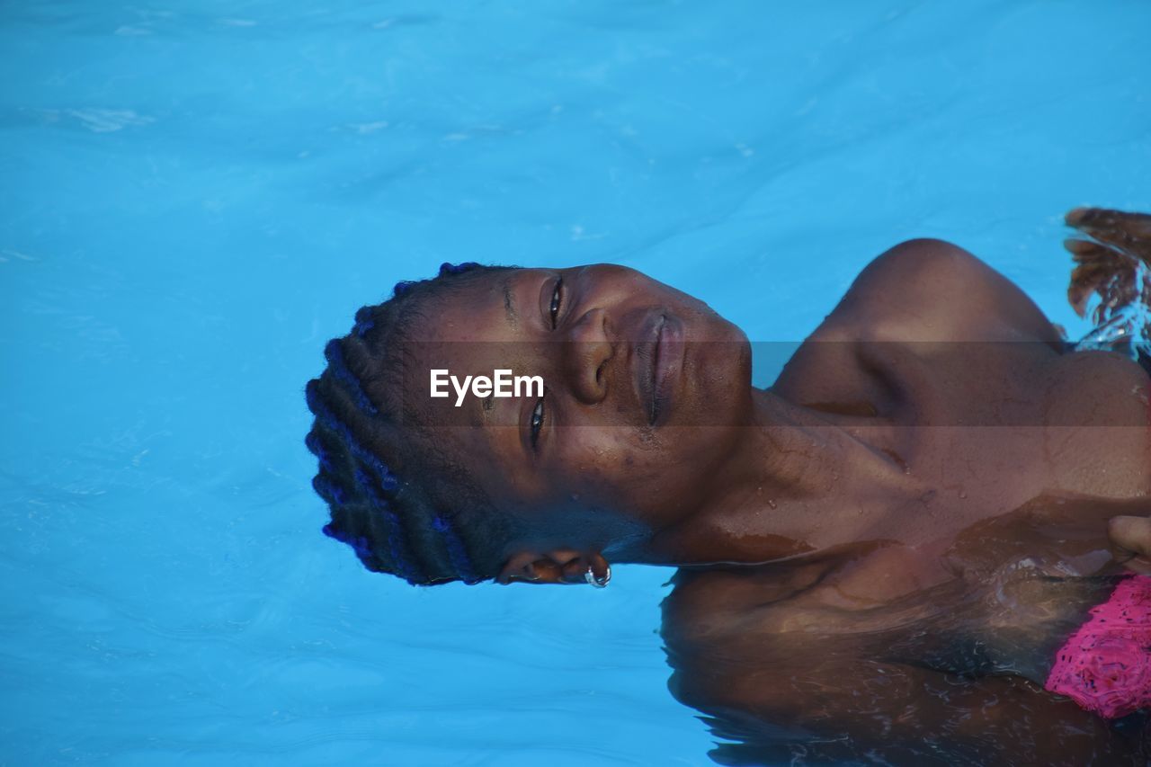 Portrait of young woman swimming in pool