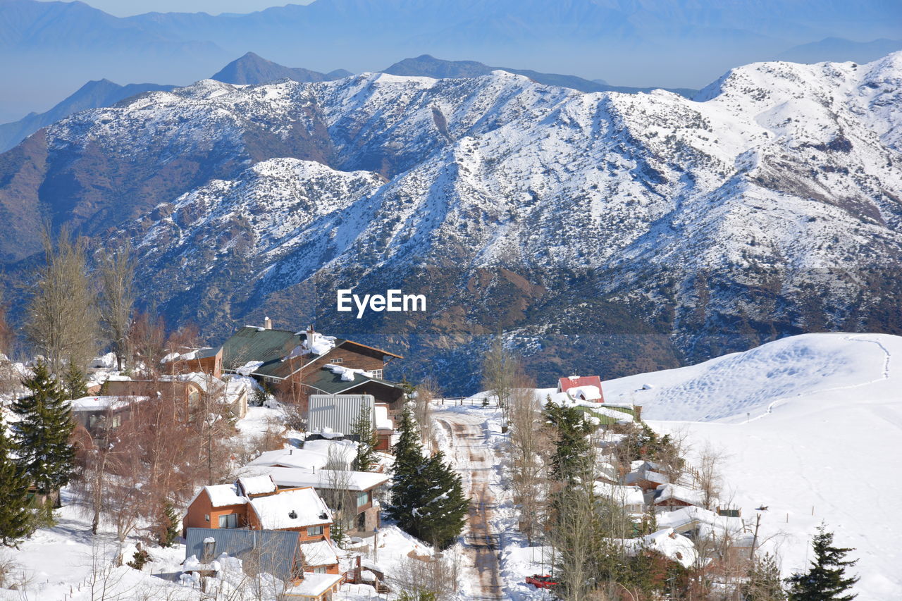 HIGH ANGLE VIEW OF HOUSES AND SNOWCAPPED MOUNTAIN