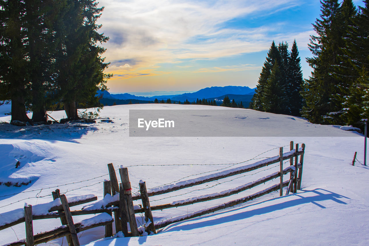 Scenic view of snow covered field against sky during winter