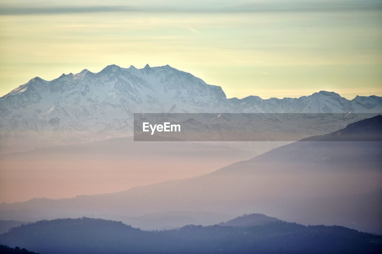 Scenic view of snowcapped mountains against sky during sunset