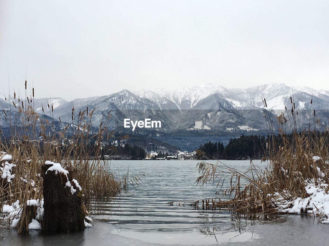 SCENIC VIEW OF FROZEN LAKE AGAINST MOUNTAINS