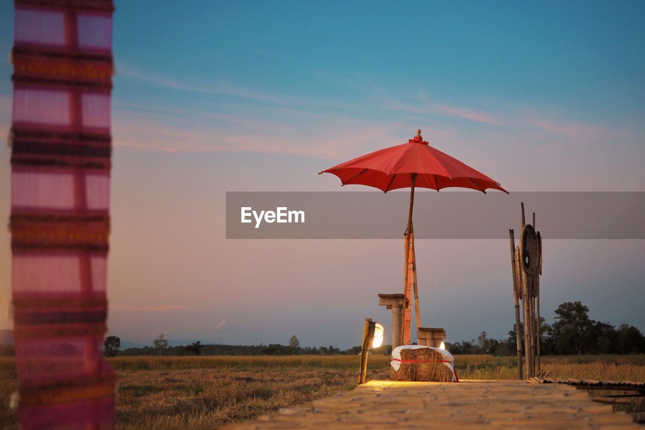 Traditional windmill on field against sky during sunset