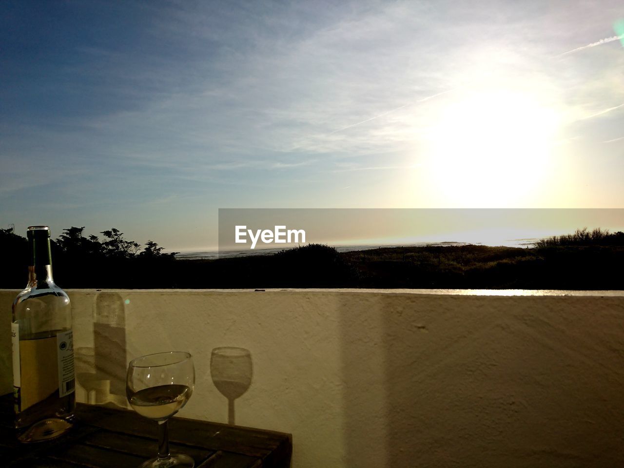 View of wine glass on table against sky during sunset