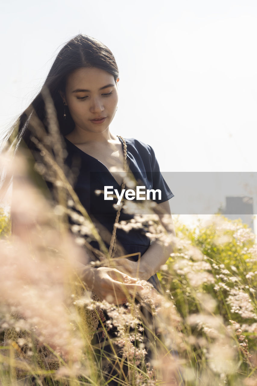 Woman standing by plant