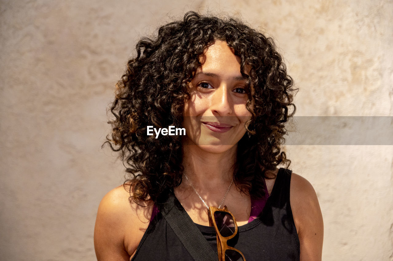 Portrait of a mixed race woman smiling while posing inside an abandoned factory.