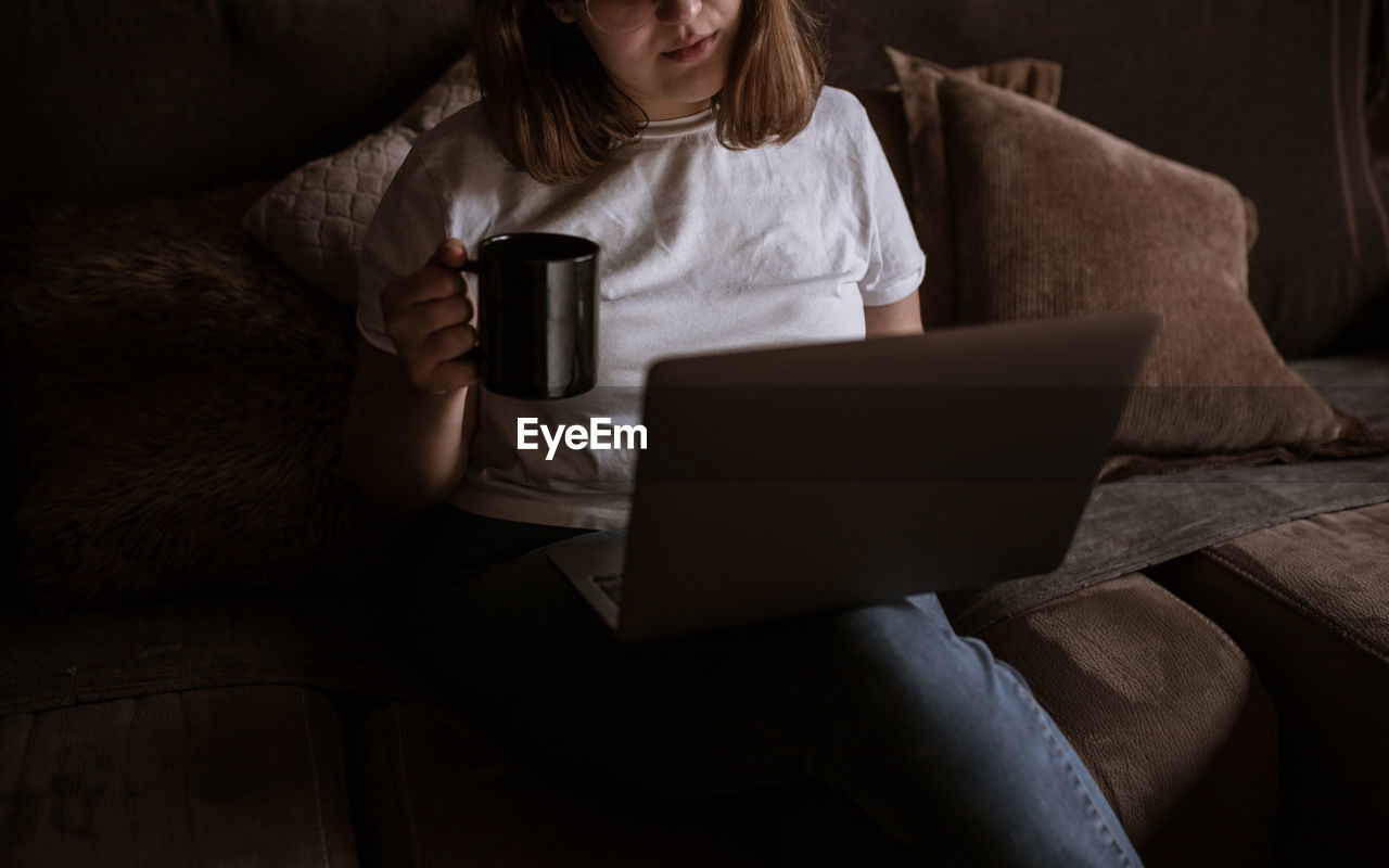 Young woman using laptop on the couch