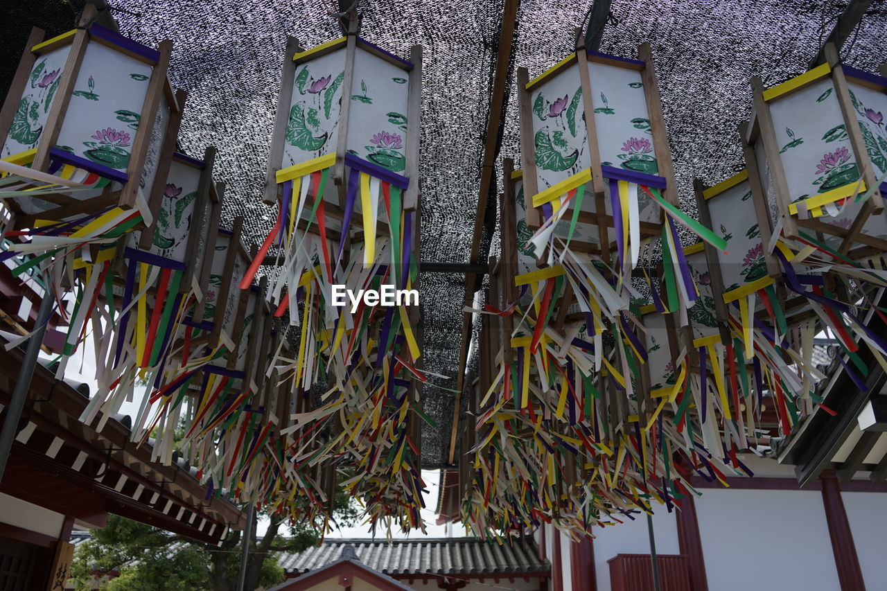 LOW ANGLE VIEW OF DECORATIONS HANGING ON BUILDING