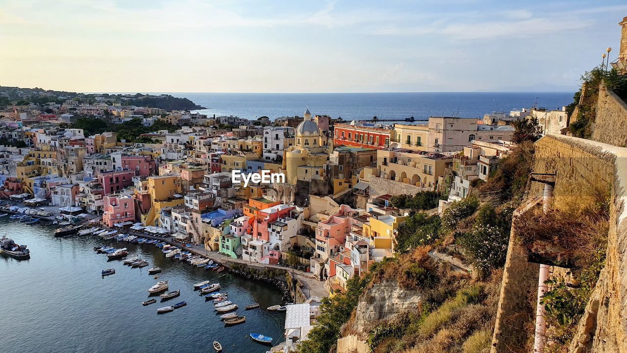 High angle view of townscape by sea against sky