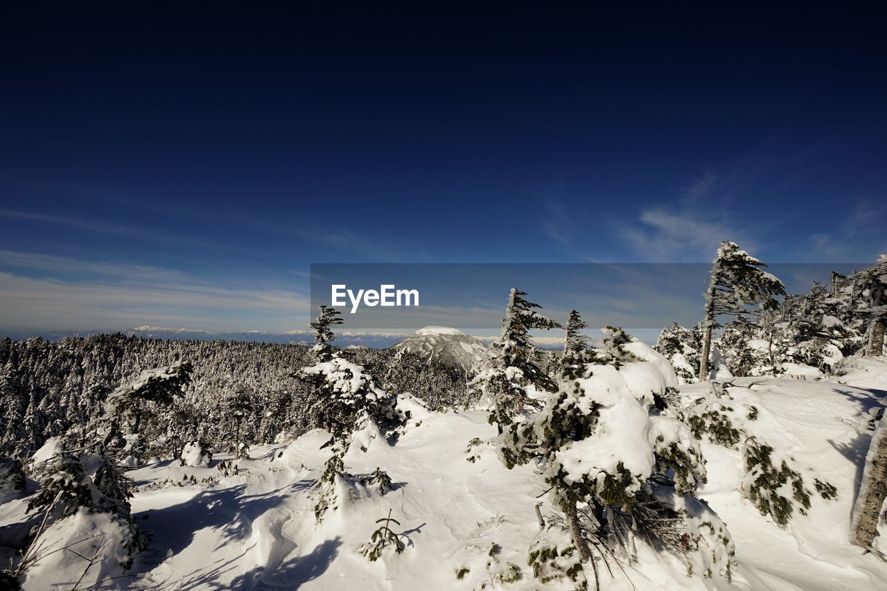 Scenic view of snowcapped mountains against blue sky