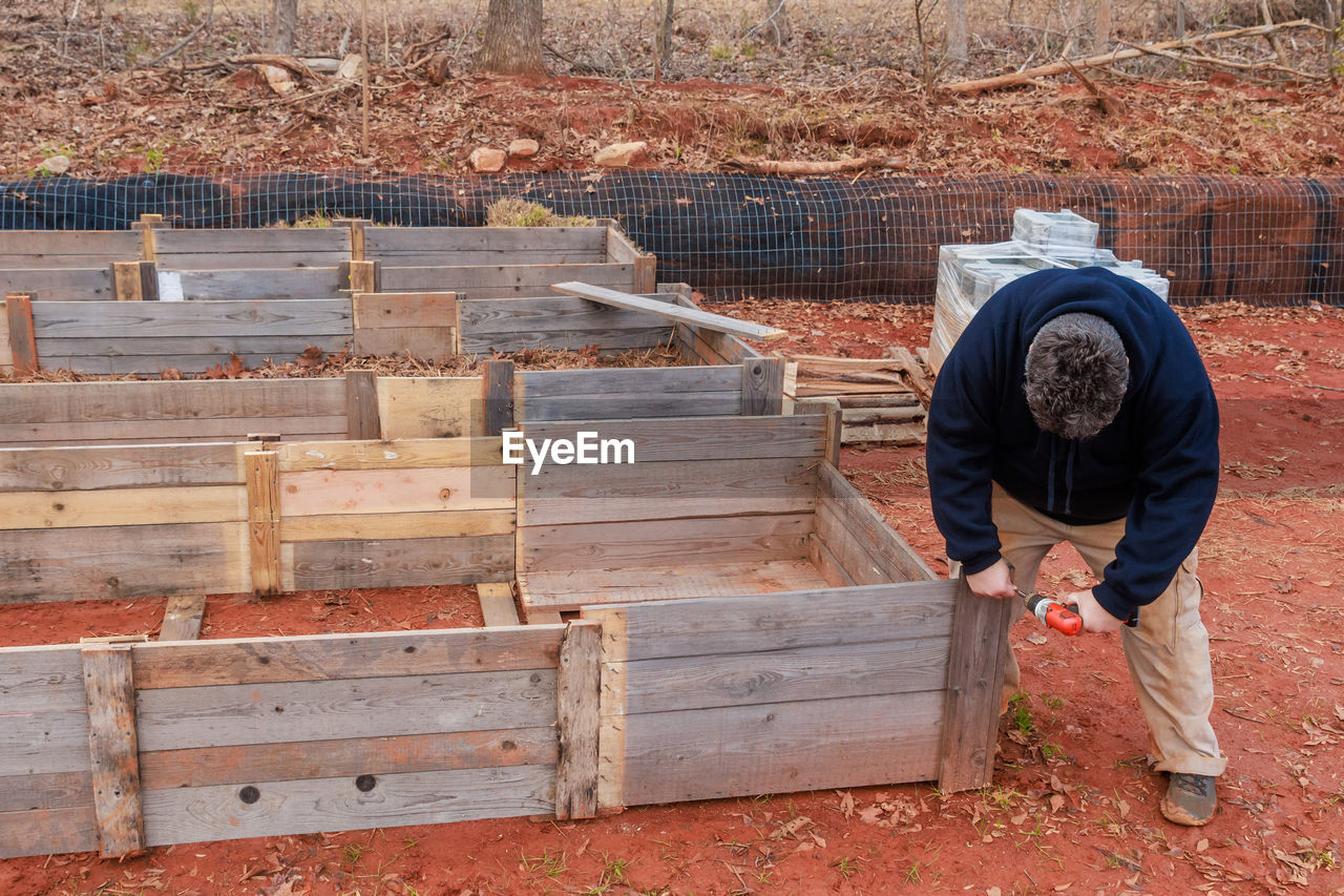 rear view of man standing on wooden wall