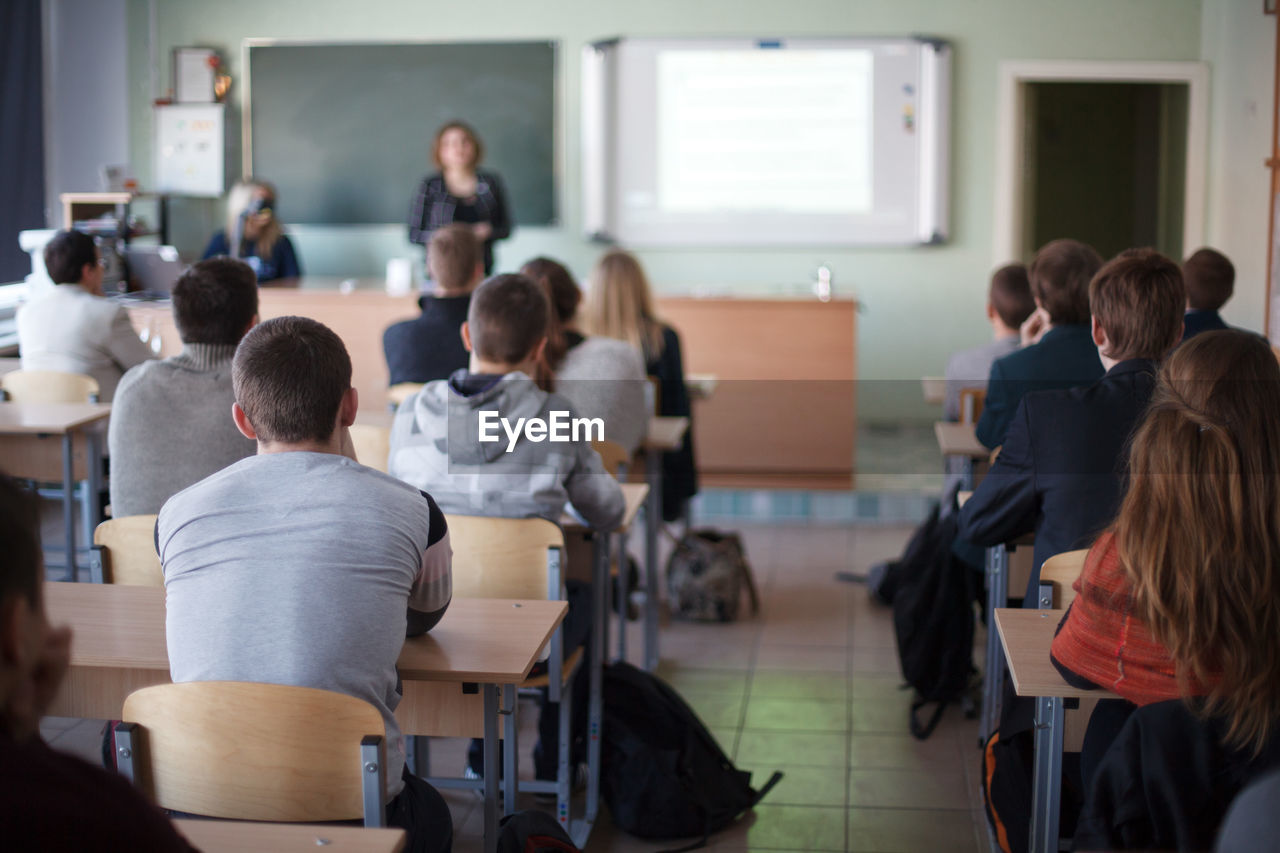 Rear view of students sitting in classroom