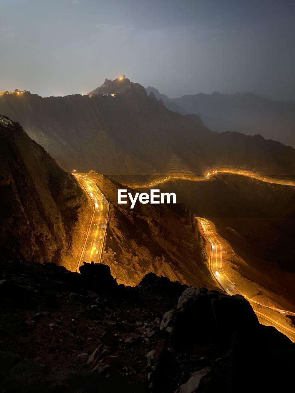 Aerial view of land and mountains against sky at night