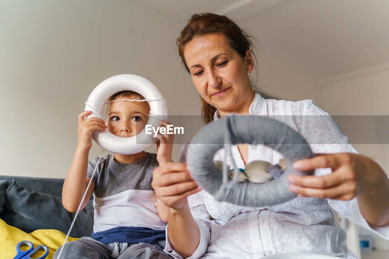 View of mother and son sitting at home