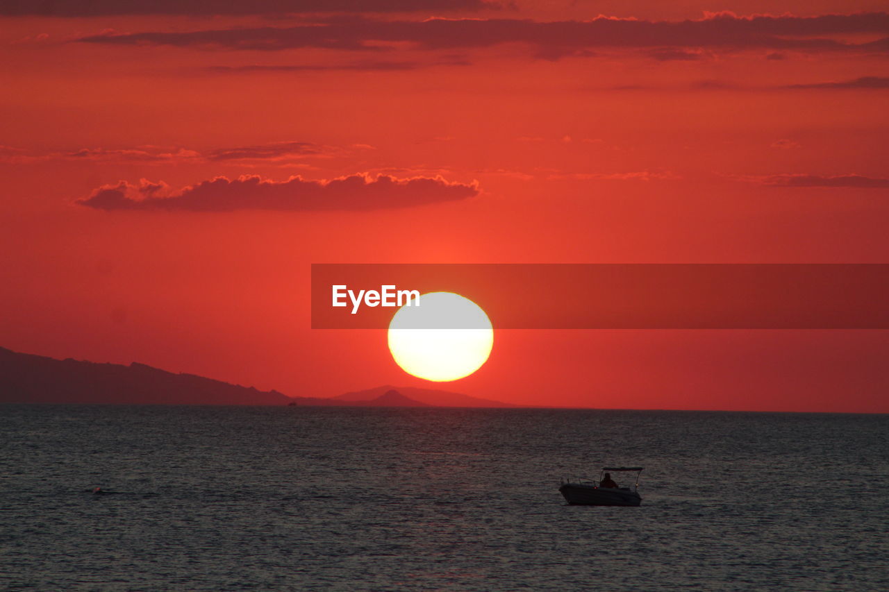 Scenic view of sea against orange sky