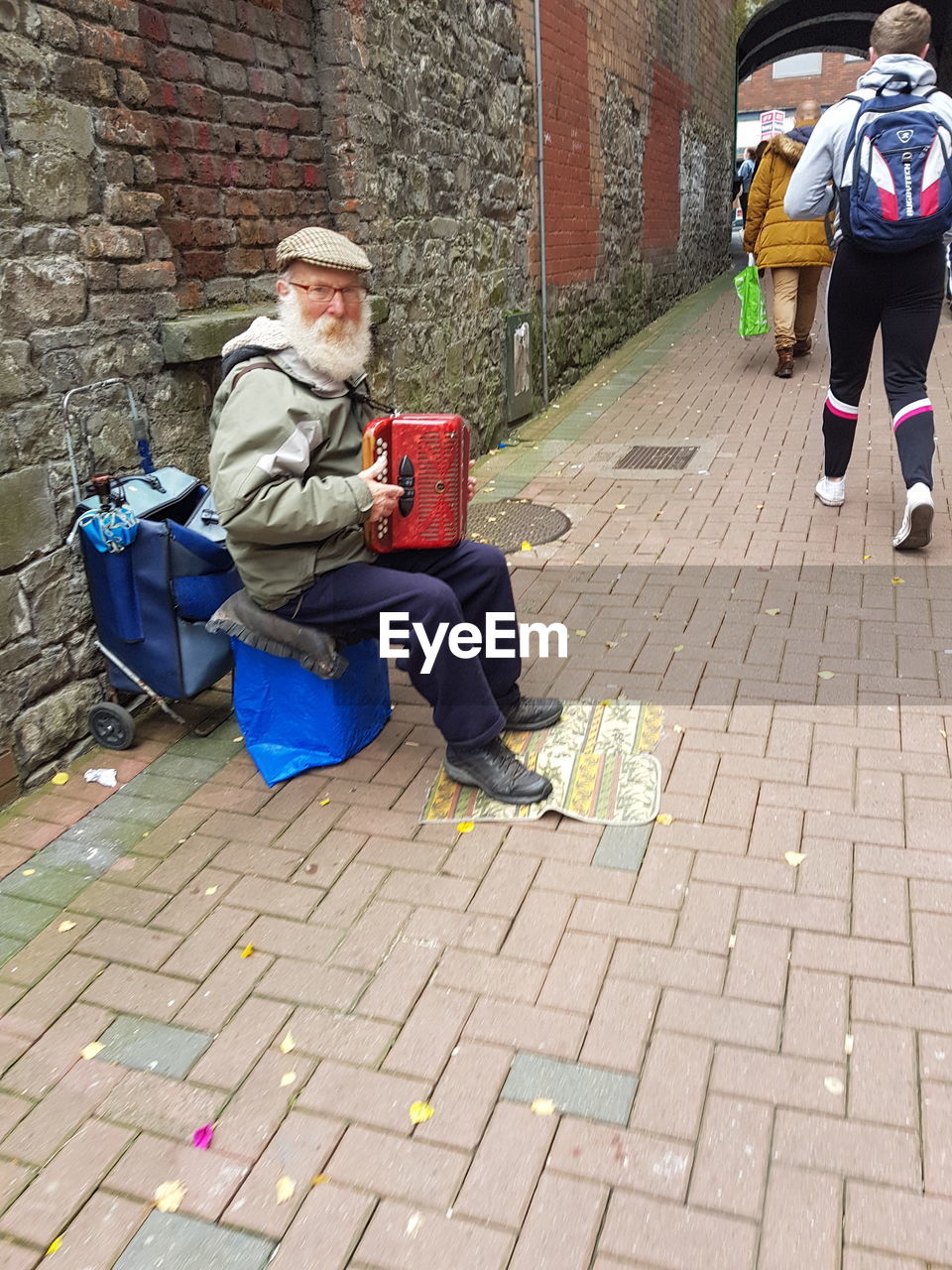 FULL LENGTH OF MAN SITTING ON COBBLESTONE