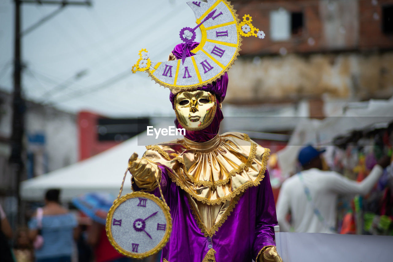 People wearing venetian carnival-style masks are seen during the carnival in the city of maragogipe,