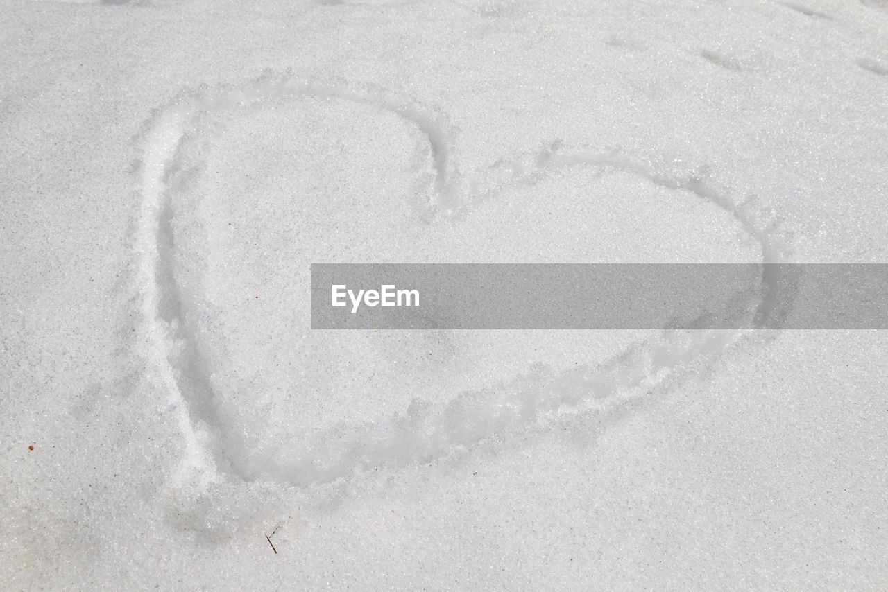 CLOSE-UP OF HEART SHAPE ON SNOW
