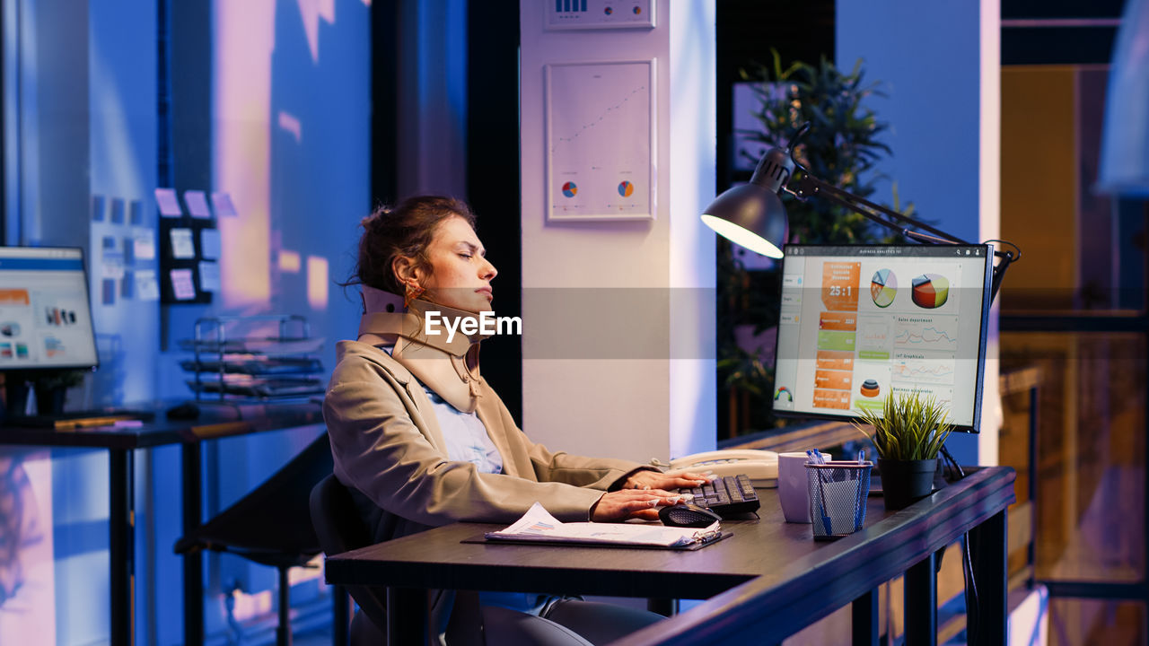 young woman using laptop while sitting at table