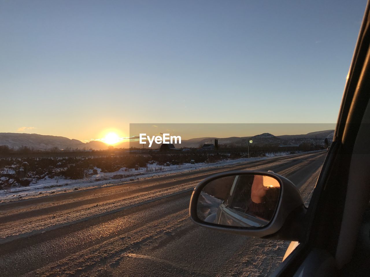 Car on road against sky during sunset