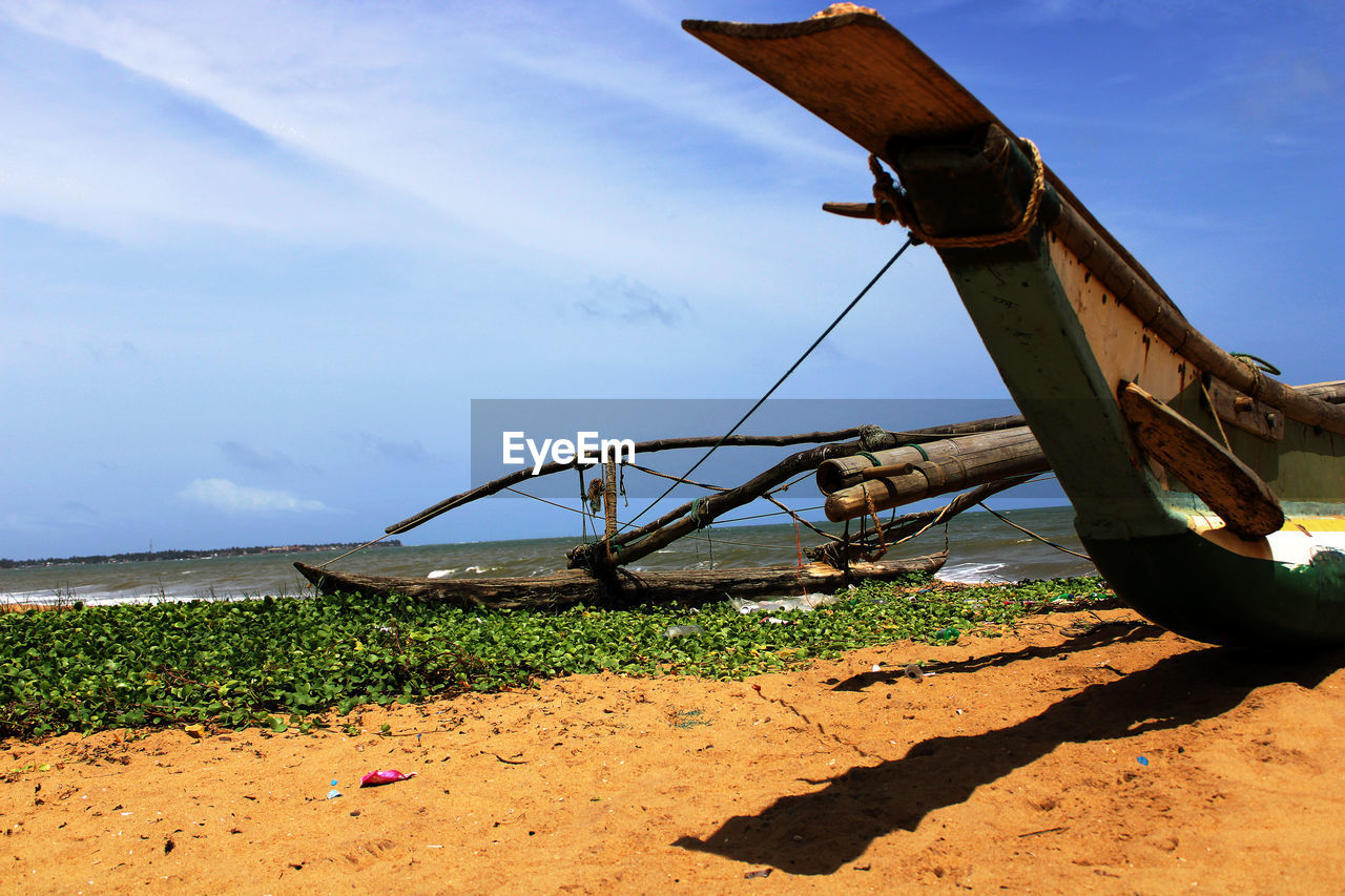 Outrigger at beach against sky