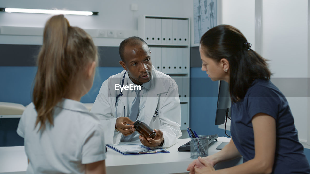 Doctor explaining medicine to patient in clinic