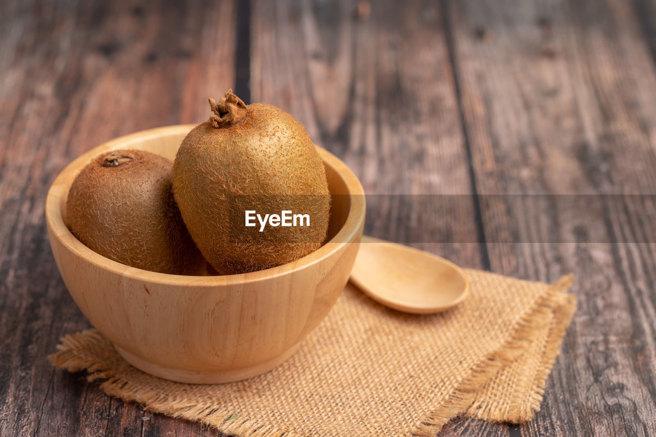 Kiwi fruit in a wood bowl on the table