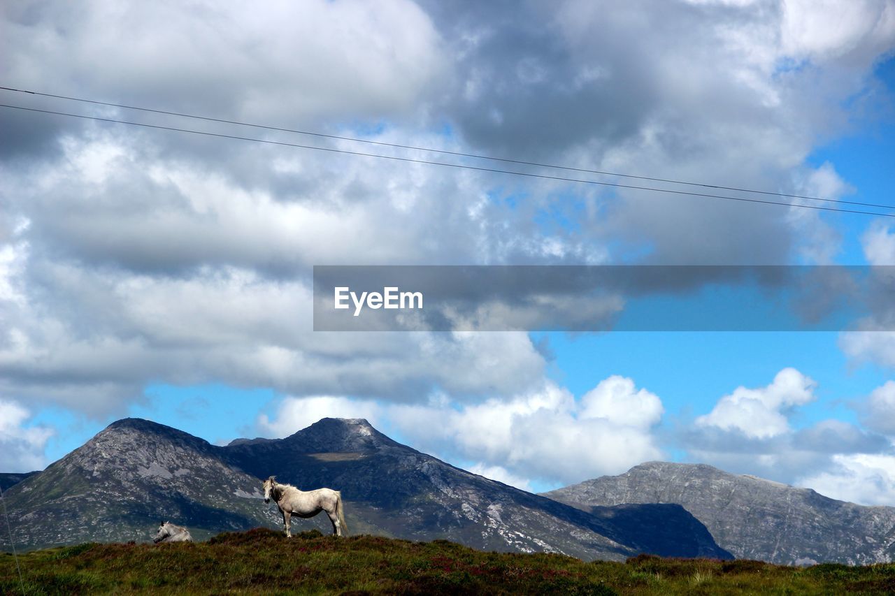 Scenic view of mountains against cloudy sky