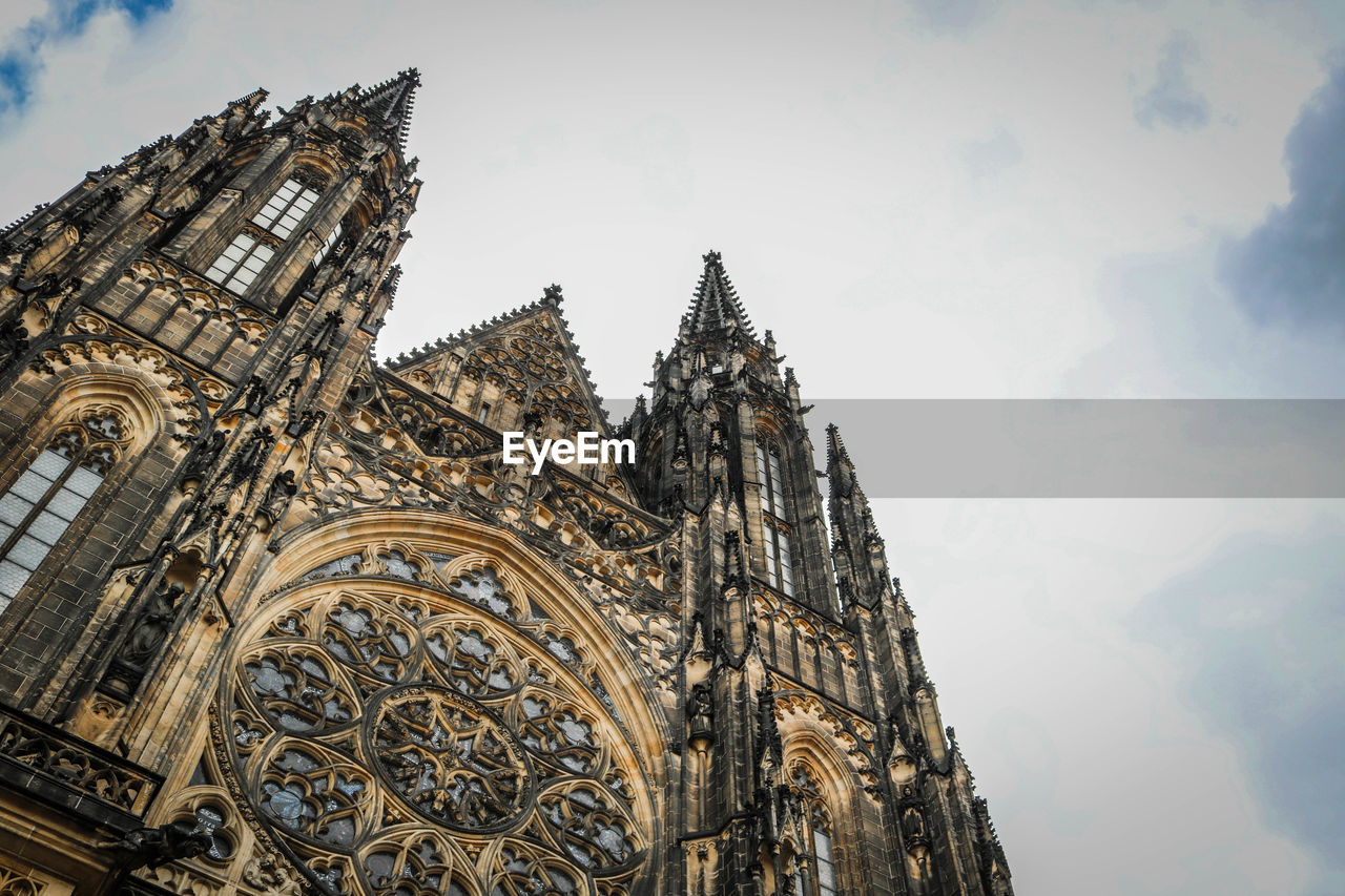 Low angle view of st vitus cathedral against cloudy sky