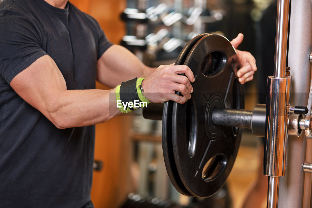 Midsection of man exercising in gym