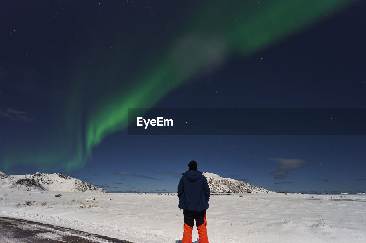 Rear view of man walking on snow