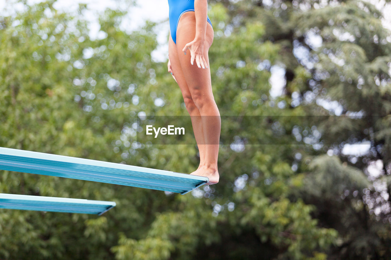 Low section of woman standing on diving platform