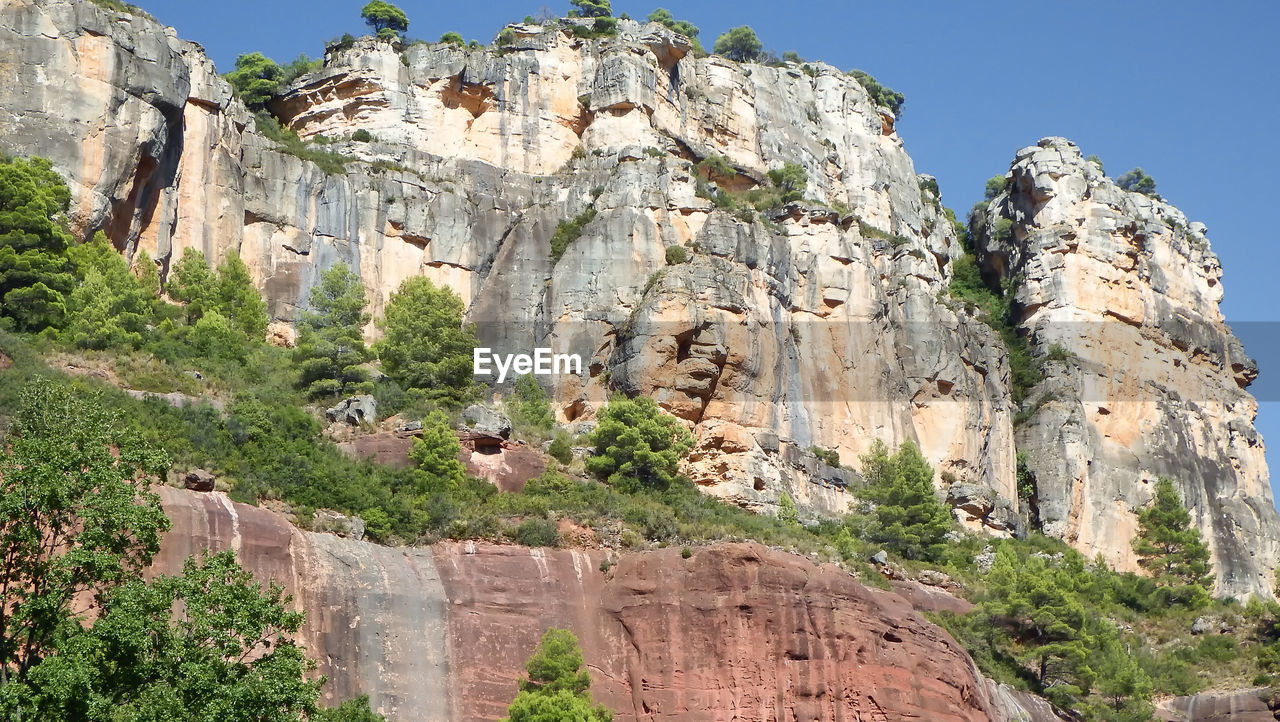 Low angle view of rocks on mountain against sky