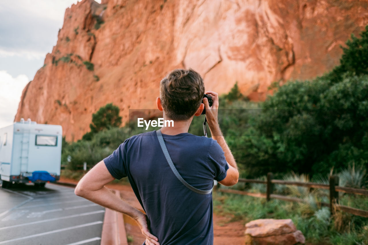 REAR VIEW OF A MAN PHOTOGRAPHING