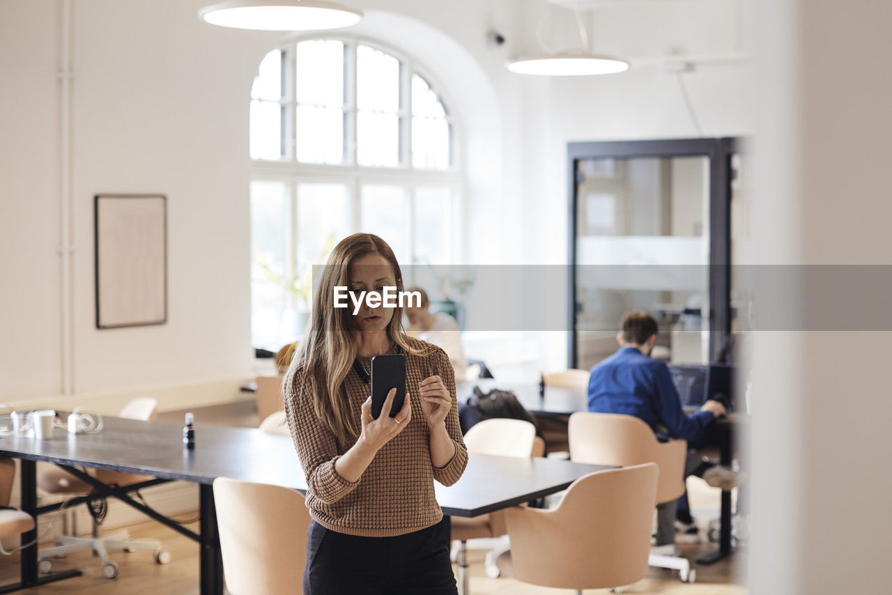 Female business professional doing video call through smart phone at office