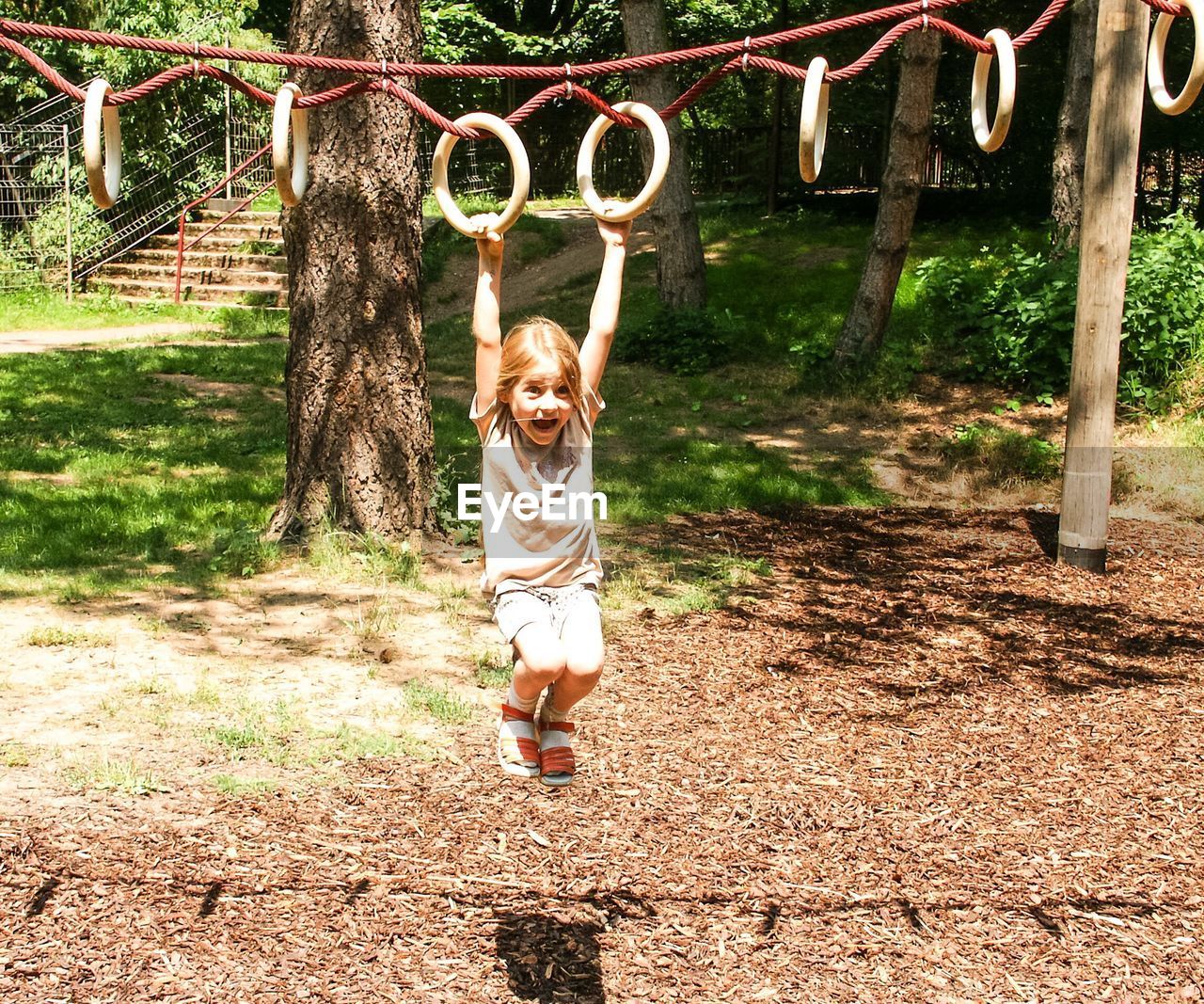 Girl hanging at jungle gym