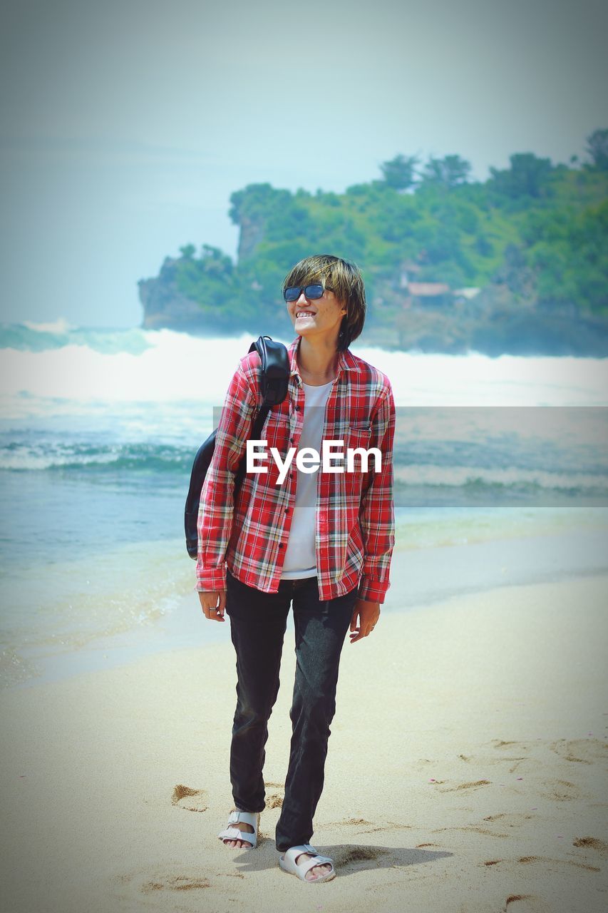 Rear view of woman standing at beach