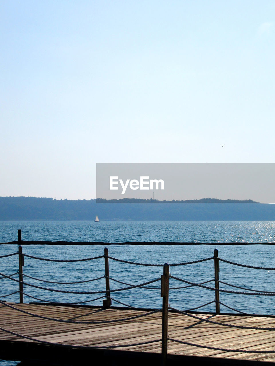 RAILING BY SEA AGAINST CLEAR SKY