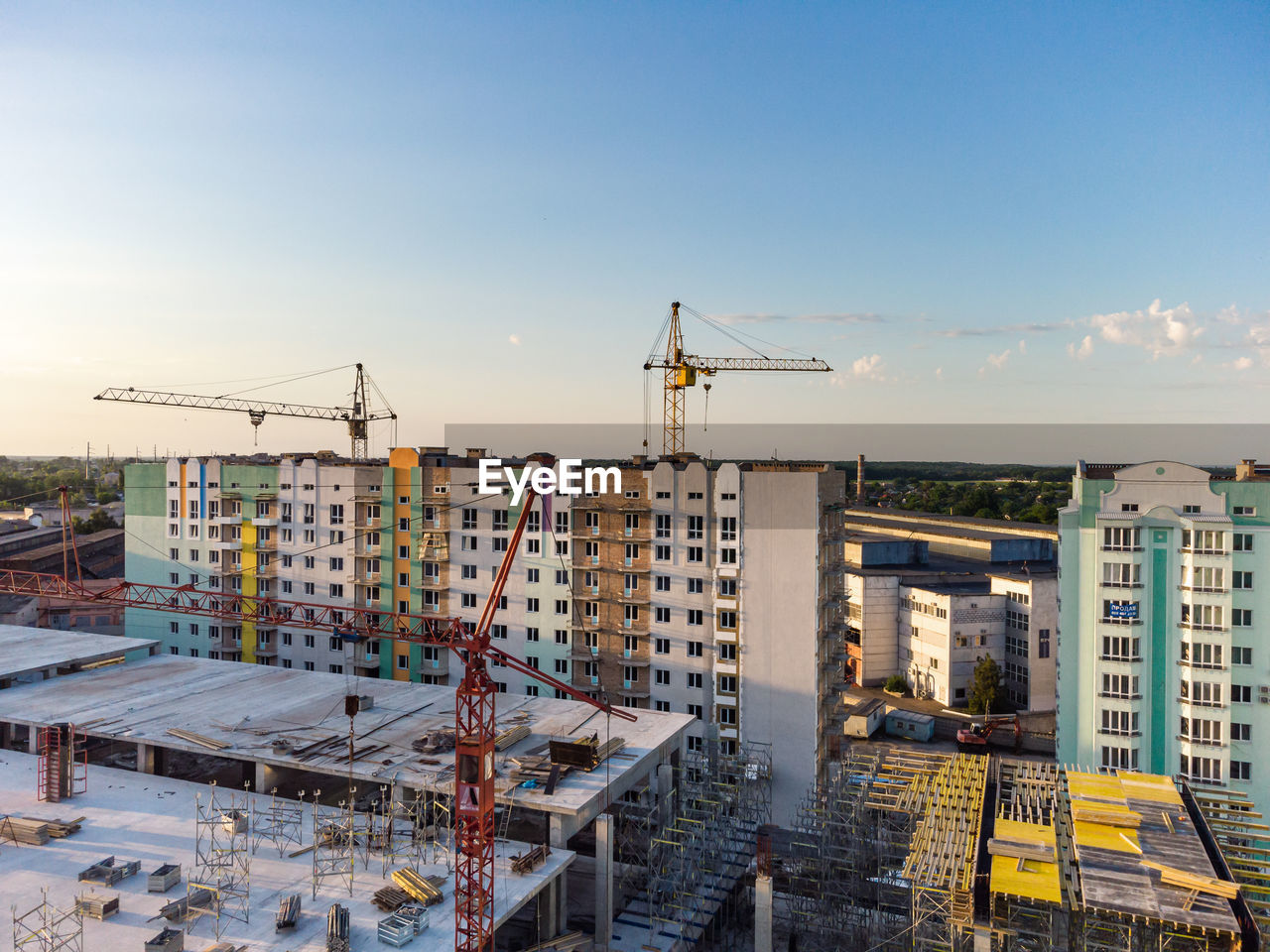 HIGH ANGLE VIEW OF CONSTRUCTION SITE AGAINST BUILDINGS